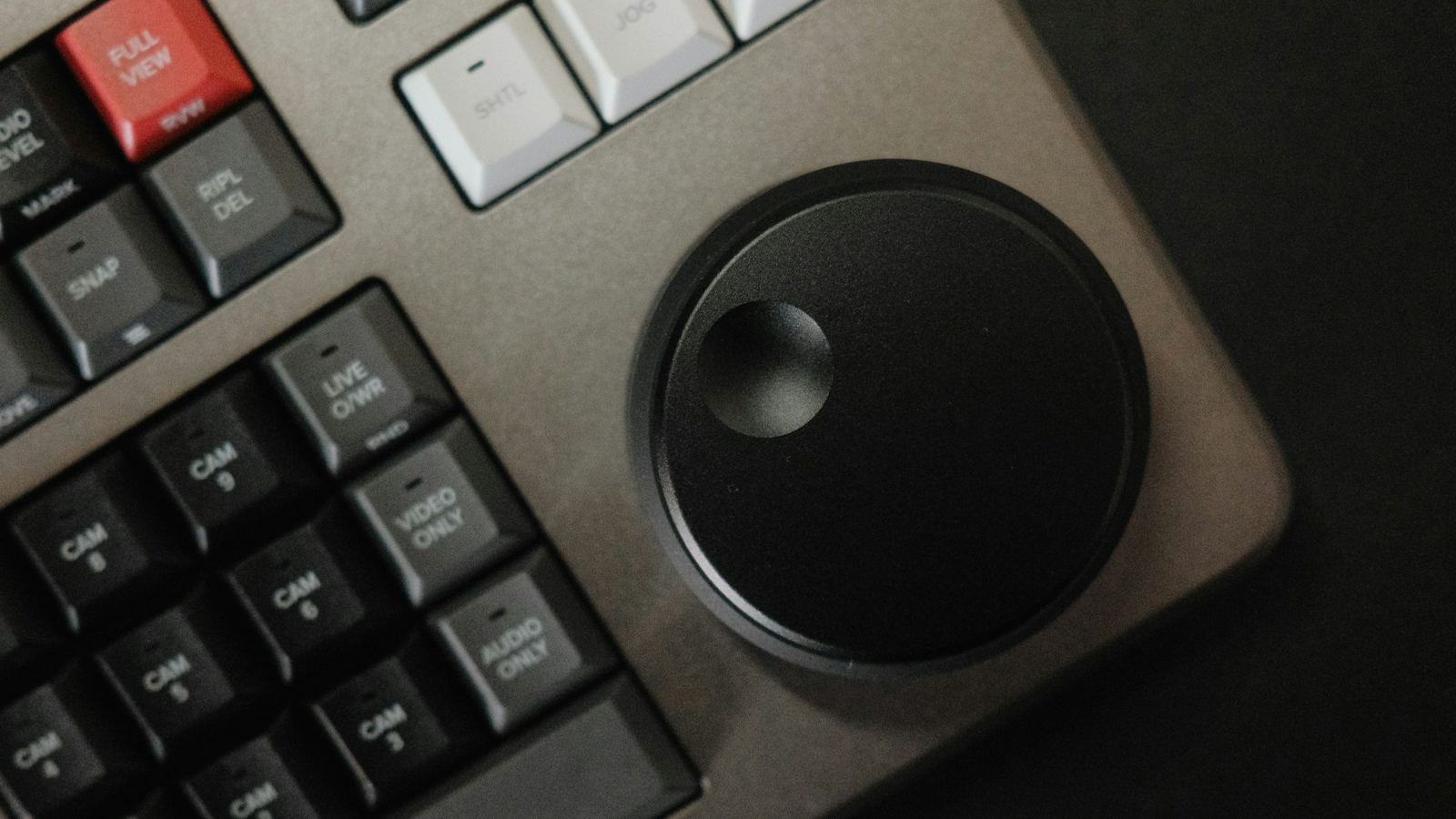 Close-up of a video editing keyboard with a jog wheel