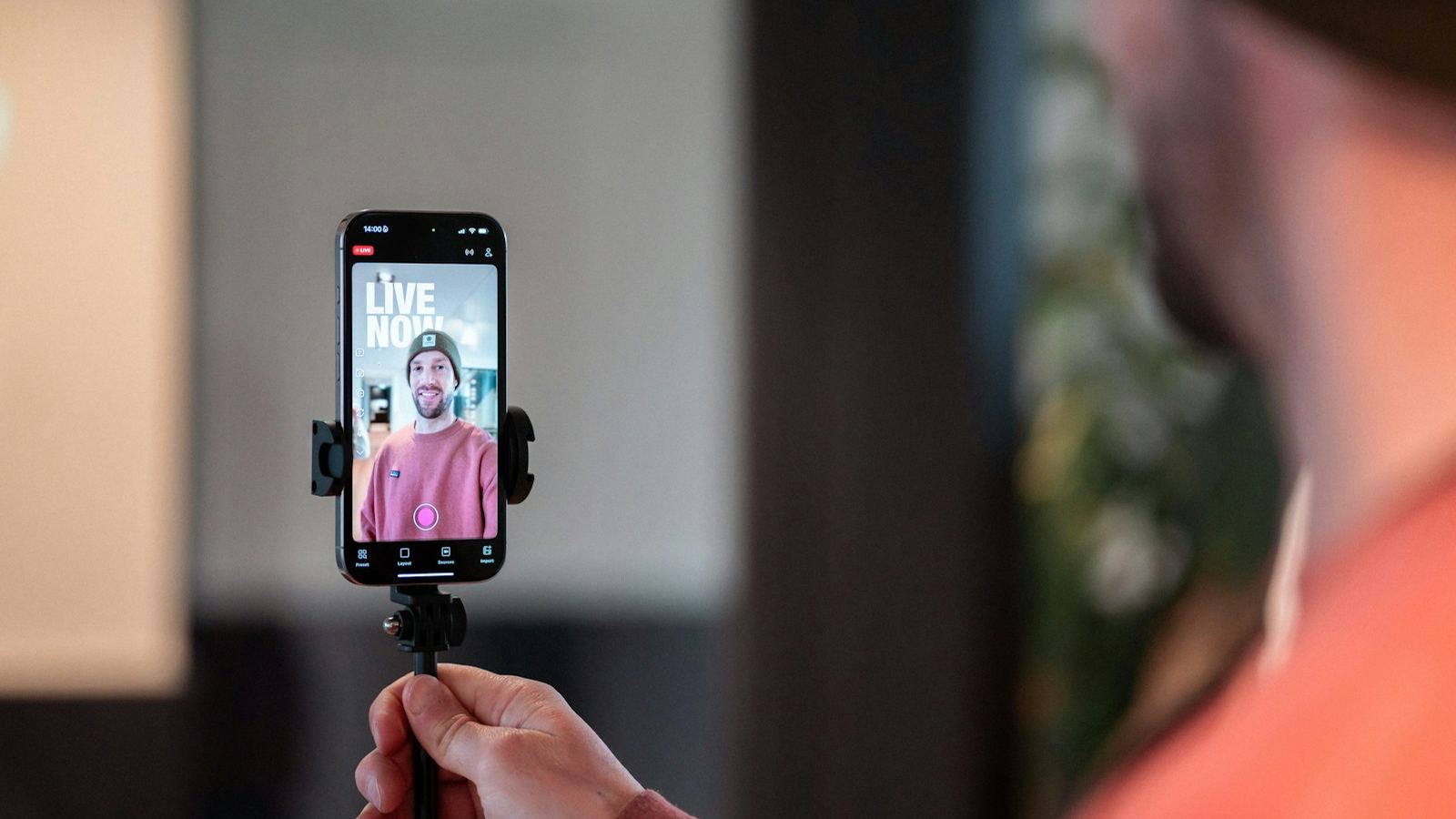 Creator filming himself on a smartphone mounted on a small tripod